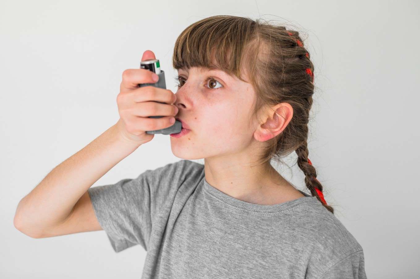 girl with asthma using an inhaler